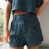 Front view of female model wearing the Jemma Navy Tweed Shorts that have navy and white tweed and side pockets. Worn with matching top.