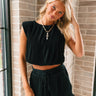 Front view of female model wearing the Madeline Black Plisse Top that has black plisse fabric, a round neck, and cropped waist. Worn with matching shorts.