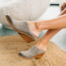 Side view of model's feet; model is wearing the Nicki Grey Mules that have brown soles and grey mule uppers.