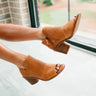 Side view of model's feet; model is wearing the Molly Tan Peep Toe Booties.