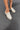 Image show's top/side view of models feet; model is wearing the Wingin It Ivory Snake Mule Loafers