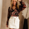 Front view of female model wearing the Carolyn Cream Denim Mini Skirt, paired with black floral top.