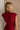 Upper body back view of female model wearing the Carey Maroon Mock Neck Sweater Dress that has maroon knit fabric, a mock neck, mini length, and is sleeveless.