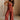 Full body front view of female model wearing the Carmella Rust Wide Leg Jumpsuit that has rust fabric, crochet trim, and wide legs.