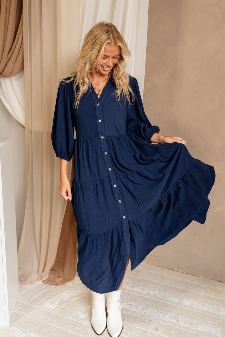 Full body front view of female model wearing the Penny Button Up 3/4 Sleeve Midi Dress in Navy that has a button up front, 3/4 sleeves, and a collar.