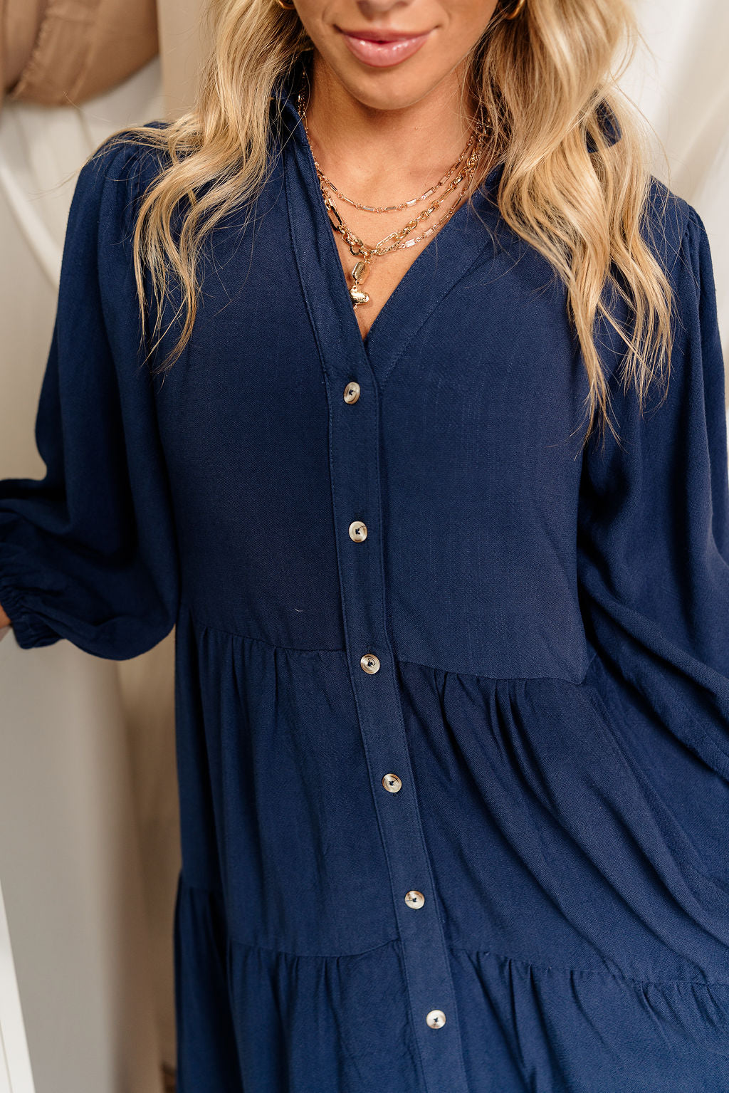 Close-up front view of female model wearing the Penny Button Up 3/4 Sleeve Midi Dress in Navy that has a button up front, 3/4 sleeves, and a collar.