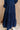 Lower body back view of female model wearing the Penny Button Up 3/4 Sleeve Midi Dress in Navy that has a button up front, 3/4 sleeves, and a collar.