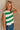 Side view of female model wearing tStacia Green & White Striped Sweater Tank, worn with jeans.