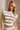 Upper body front view of female model wearing the Kiera White & Mocha Striped Top, paired with matching skirt.