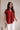 Model is shown wearing the Hazel Blouse in red.