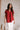 Model is shown wearing the Hazel Blouse in red.