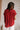 Model is shown wearing the Hazel Blouse in red.