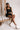 Model shown sitting while wearing the Giselle Black Shorts with matching top.