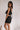 Side view of female model wearing the Giselle Black Shorts with matching top.