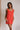 Front view of female model wearing the Peyton Denim Zip Front Mini Dress in red, that has washed red denim fabric, a gold front zipper, straps with buckle adjustments, and pockets.