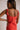 Close-up  back view of female model wearing the Peyton Denim Zip Front Mini Dress in black, that has washed black denim fabric, a gold front zipper, straps with buckle adjustments, and pockets.