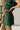 Lower body side view of female model wearing the Sutton Green Knit Mini Skirt