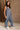 Full body side view of female model wearing the Arwen Sleeveless Jumpsuit in the color Slate Blue