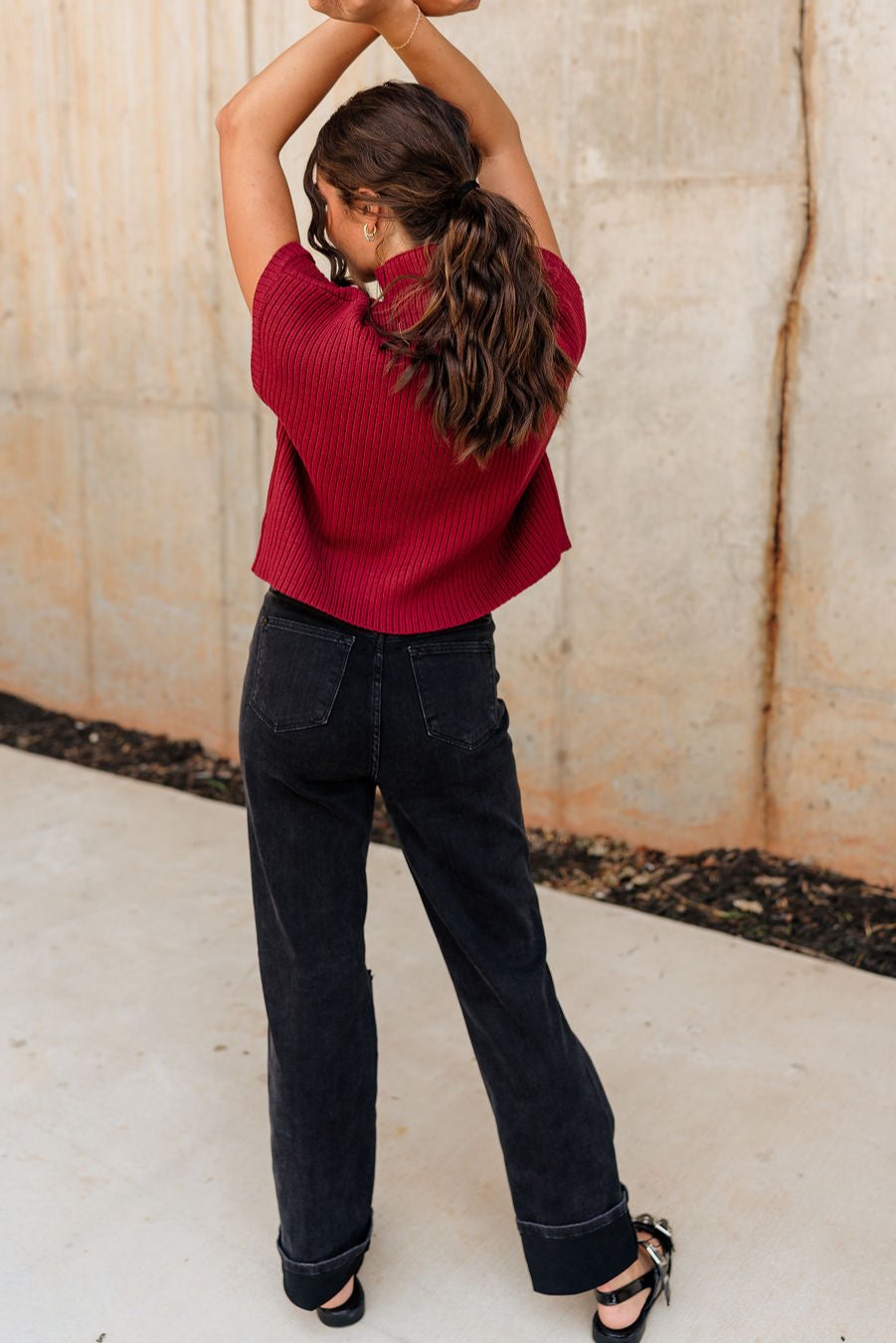 Full body back view of model wearing the Judy Blue: Alicia Black Straight Leg Jeans which features washed black denim, two front pockets, two back pockets, front zipper with button closure, belt loops, distressed details, busted knee details and straight pant 