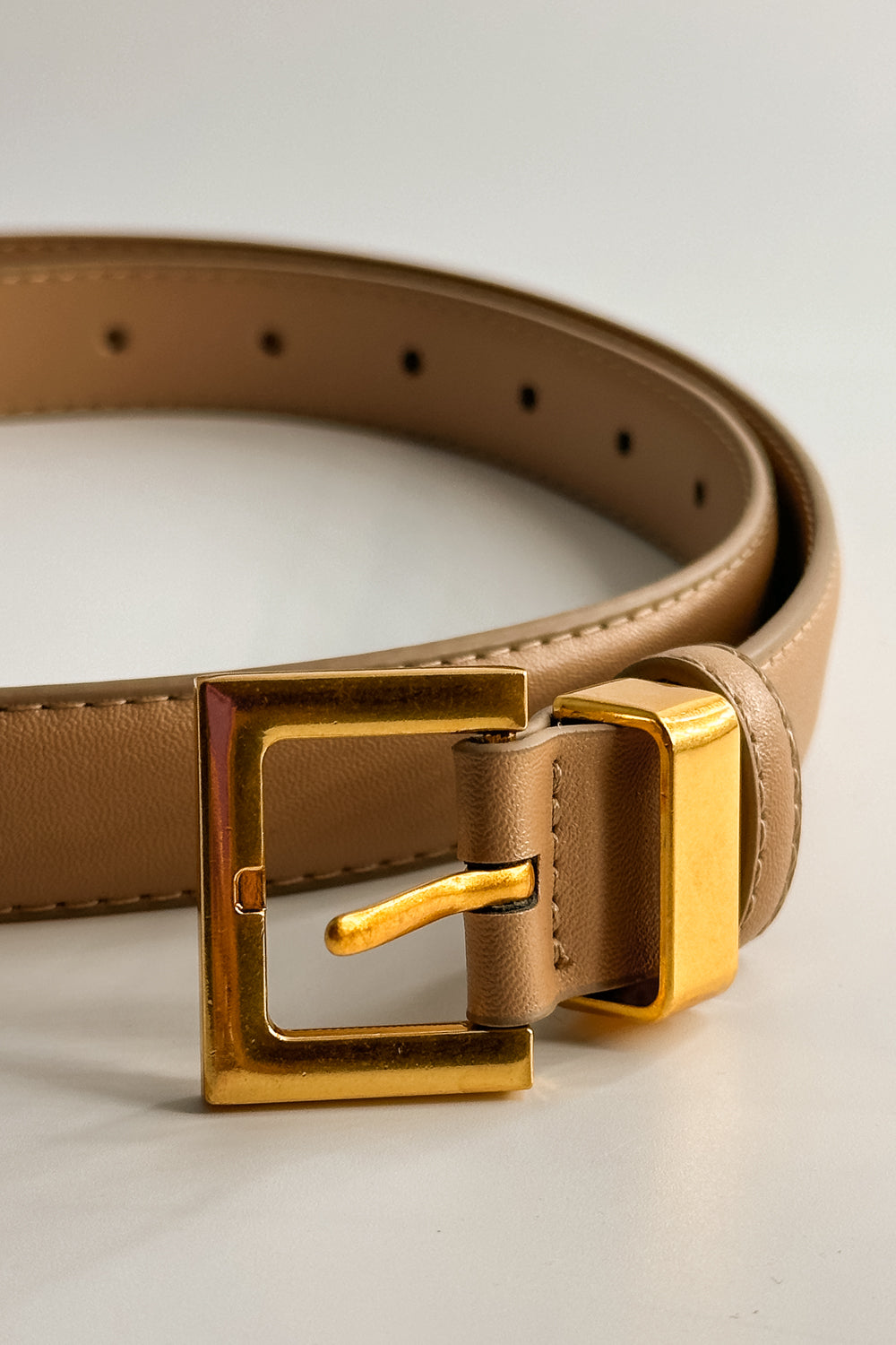 Close up view of the Iris Taupe Slim Square Buckle Belt which features taupe Leather Fabric and Gold Square Adjustable Buckle