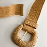 Flat lay view of the Nova Light Tan Rattan Belt which features khaki rattan fabric, monochrome rattan covered adjustable buckle 
