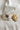 Flat lay view of the Chloe White & Gold Flower Stud Earring which features oversized white flower studs with gold details