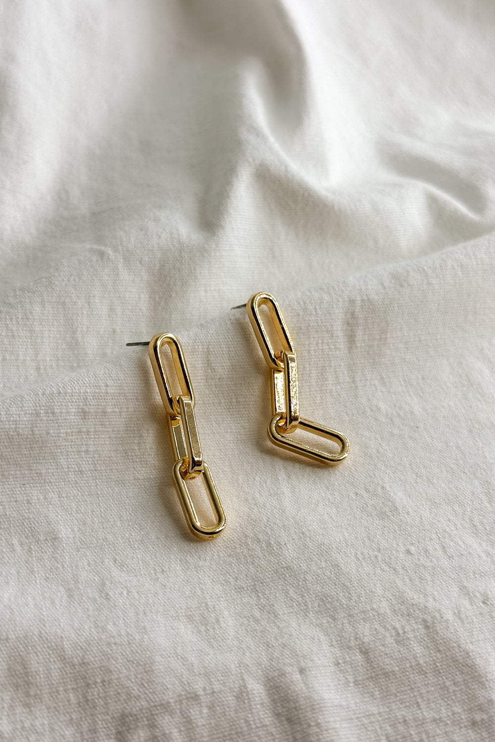 Flat lay view of the Emma Gold Chain Dangle Earring which features gold chain link dangle earrings