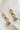 FLat lay view of the Rhodes Gold & Cream Chain Dangle Earring which features gold chain link dangle earrings with cream textured beads