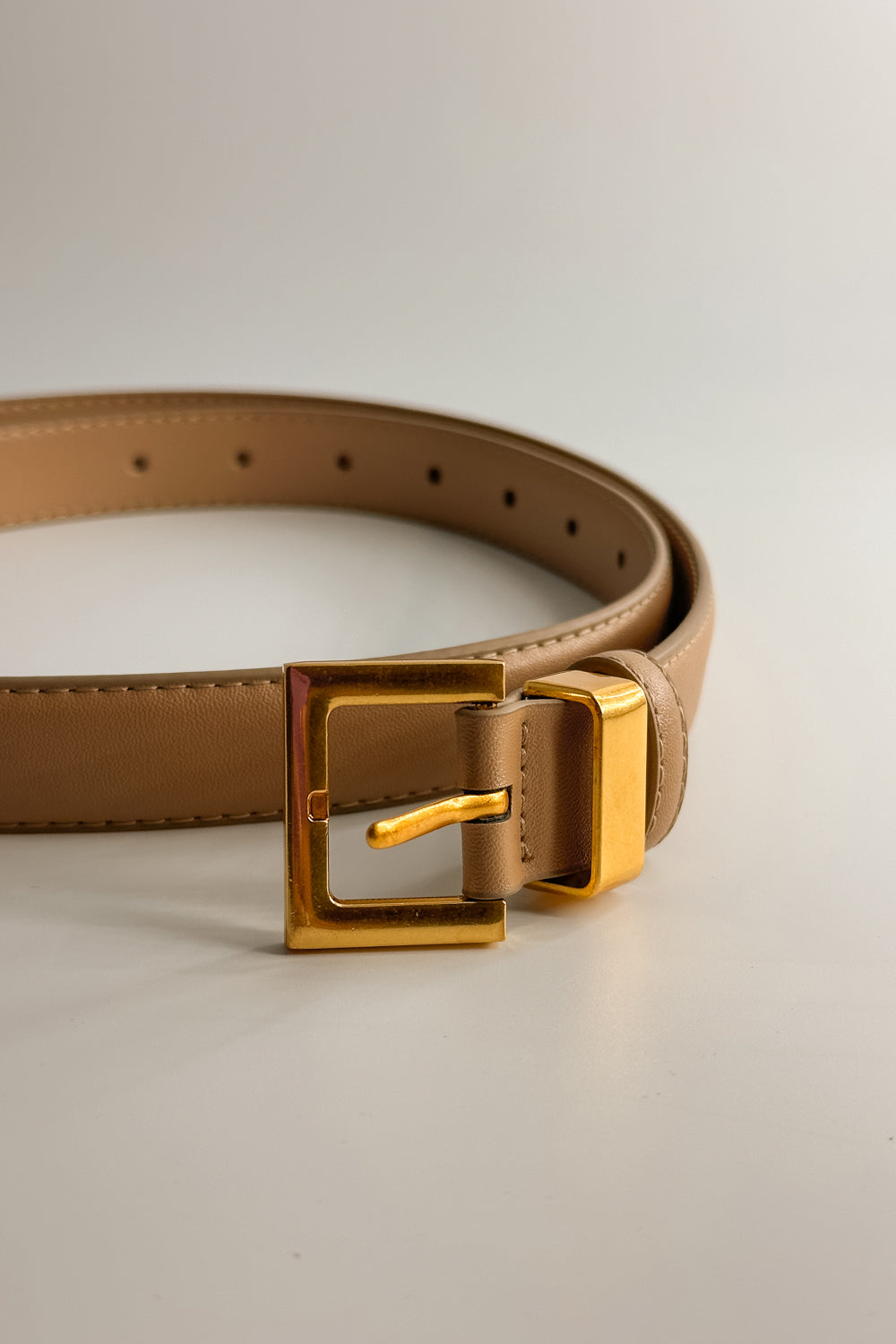 Front close up view of the Iris Taupe Slim Square Buckle Belt which features taupe Leather Fabric and Gold Square Adjustable Buckle