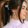 Side view of female model wearing the Stephanie Gold & White Pearl Dangle Earring which features white pearls and gold beads, teardrop dangle earring
