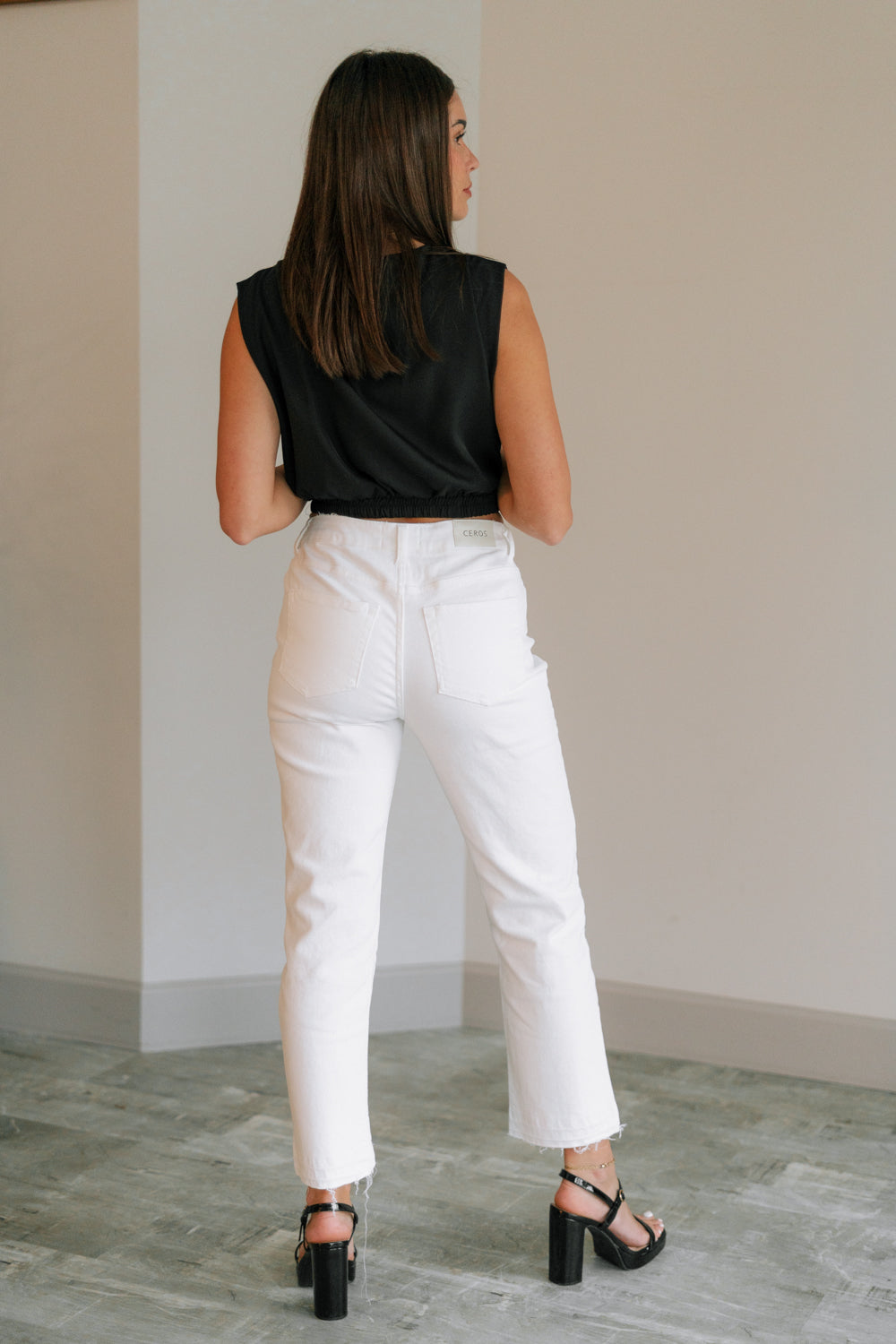 Back view of female model wearing the Ayla White Straight Leg Jeans White Denim Fabric, Straight Leg, Two Front Pockets, Two Back Pockets, Front Zipper with Button Closure and Fray Hem