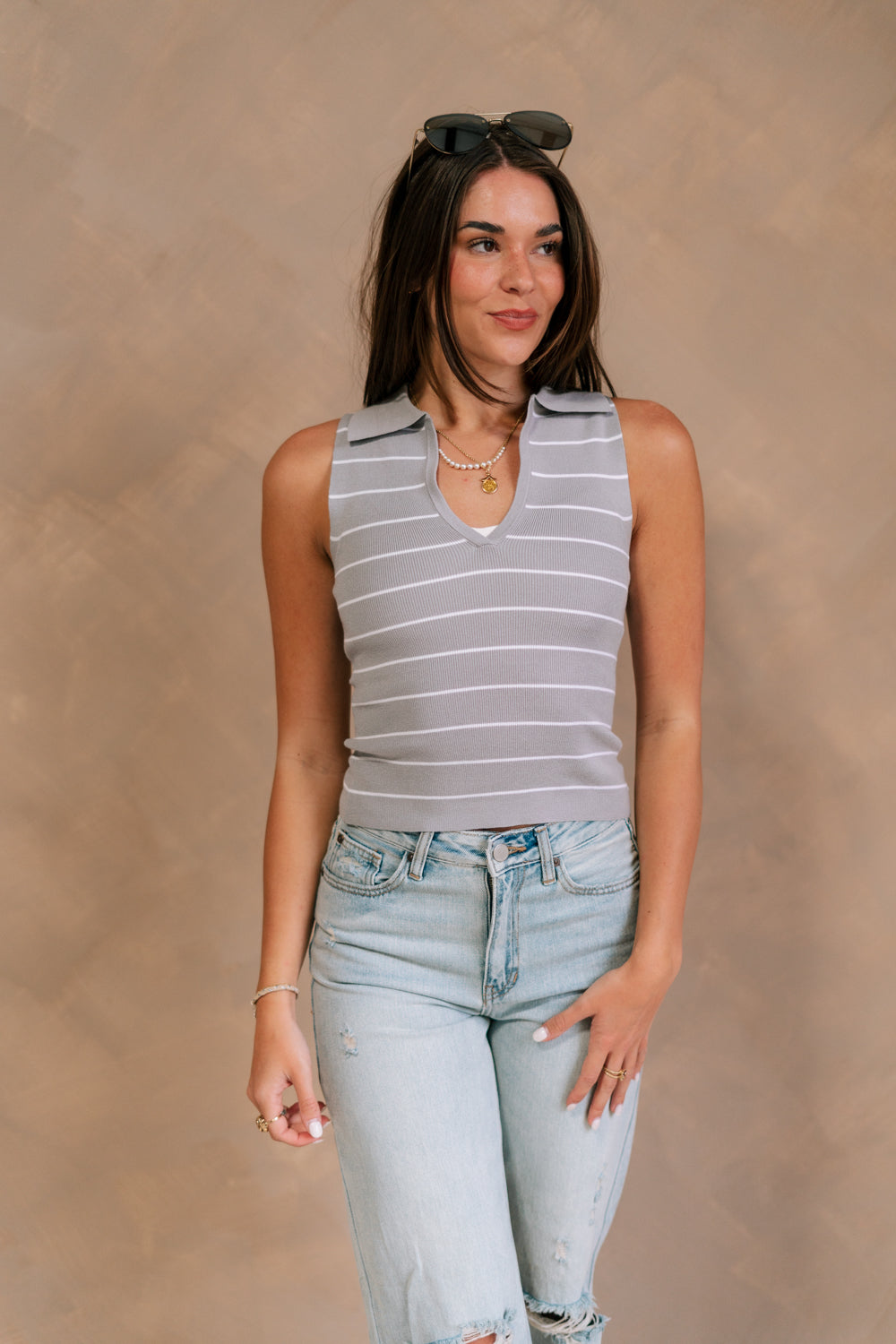 Front view of female model wearing the Cali Grey and White Stripe Sleeveless Tank which features Grey and White Knit Fabric, Stripe Pattern, Collared Neckline and Sleeveless