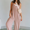 Full body view of female model wearing the Noelle Taupe Ribbed Sleeveless Jumpsuit which features Taupe Ribbed Fabric, Jogger Pant Legs, Two Side Pockets and V-Neckline