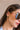 Side view of female model's face; model is wearing the Evelyn Layered Gold Hoop Earring that feature 3 small gold hoops attached together.