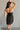 Upper body back view of model wearing the Sarah Black Strapless Mini Dress that has black fabric with metallic black florals and a strapless neckline.