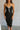 front view of model wearing the Gianna Black & White Midi Dress that has black fabric, and white straps with white neckline bow trim. 