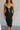 front view of model wearing the Gianna Black & White Midi Dress that has black fabric, and white straps with white neckline bow trim. 