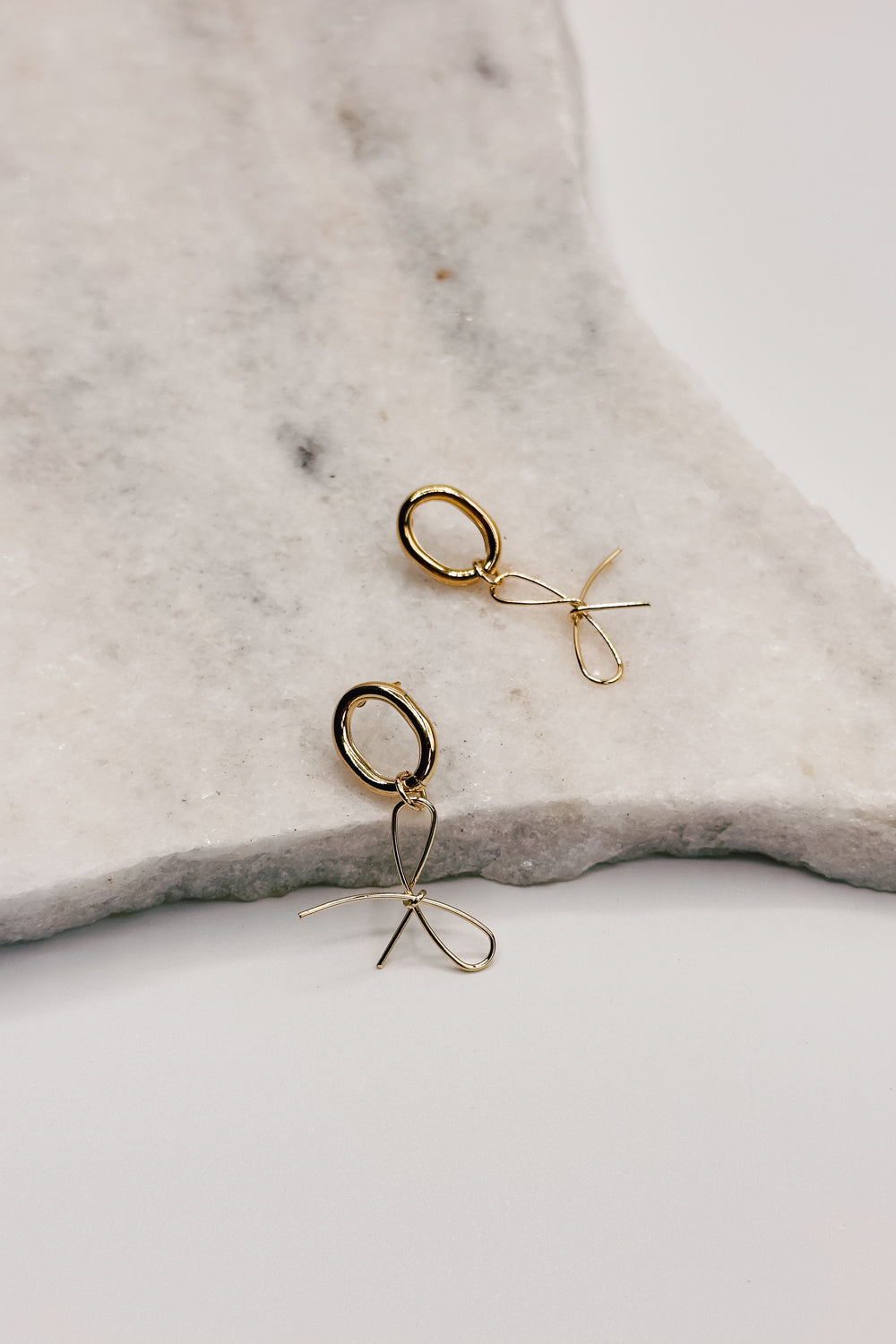 front view of the Valeria Gold Dipped Bow Dangle Earring which features gold dipped bow shaped dangle earrings