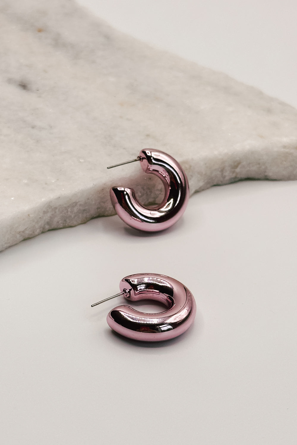 close up view of the Amaya Gold Dipped Pink Mini Hoop Earring which features gold dipped pink mini hoops