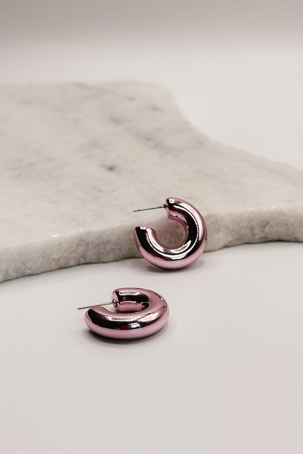 close up view of the Amaya Gold Dipped Pink Mini Hoop Earring which features gold dipped pink mini hoops