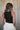 Back view of female model wearing the Julie Ribbed Sleeveless Tank in Black which features Ribbed Lightweight Fabric, Round Neckline and Sleeveless.