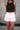 Front view of female model wearing the Katherine Tortoise Buttoned Shorts in White which features Cotton Fabric, Two Front Pockets, Two Back Pockets, Belt Loops and Front Zipper with Tortoise Button Closure