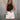 Front view of female model wearing the Julie Ribbed Sleeveless Tank in Black which features Ribbed Lightweight Fabric, Round Neckline and Sleeveless.