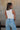 Back view of female model wearing the Julie Ribbed Sleeveless Tank in White which features Ribbed Lightweight Fabric, Round Neckline and Sleeveless.