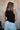 Back view of female model wearing the Brielle Black Sleeveless Tank which features Black Lightweight Fabric, Round Neckline and Sleeveless