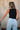 Back view of female model wearing the Brielle Black Sleeveless Tank which features Black Lightweight Fabric, Round Neckline and Sleeveless