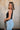 Side view of female model wearing the Brielle Black Sleeveless Tank which features Black Lightweight Fabric, Round Neckline and Sleeveless