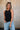 Front view of female model wearing the Brielle Black Sleeveless Tank which features Black Lightweight Fabric, Round Neckline and Sleeveless