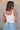 back view of female model wearing the Leigh Square Neckline Sleeveless Tank which features Ribbed Lightweight Fabric, Square Neckline and Sleeveless. the tank is available in white and black.