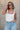 Front view of female model wearing the Leigh Square Neckline Sleeveless Tank which features Ribbed Lightweight Fabric, Square Neckline and Sleeveless. the tank is available in white and black.